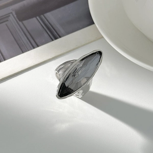 Dettaglio macro della pietra acrilica grigia a marquise su anello in argento martellato