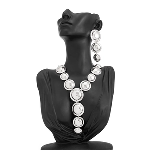 Dettaglio del set collana e orecchini con dischi d'argento lucido su manichino nero