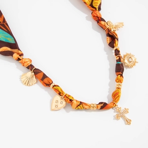 Detail of silk scarf choker with gold charms including rhinestone heart and cross pendants