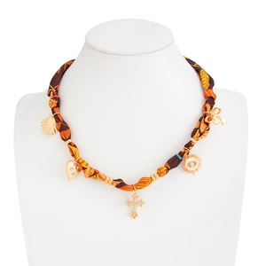 Macro shot of silk scarf choker necklace with gold heart and cross leaf charms