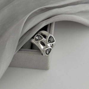 Dettaglio del bracciale elastico argento con tre pietre acriliche triangolari grigio scuro