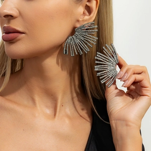 Detailed close-up of oversized fanned earrings with crystals worn by a model