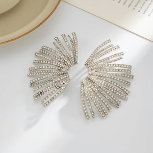Macro detail of silver fan-shaped earrings with micro-pave crystals on white background