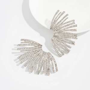 Macro shot of silver fan-shaped earrings with sparkling cubic zirconia on white background