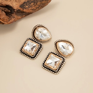 Gros plan de boucles d'oreilles de style cour avec cristaux clairs et métal or et argent