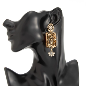 Détail d'un pendentif vintage doré avec résine ambrée et goutte de fleur en cristal