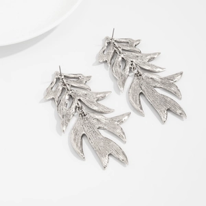 Detailed view of layered fan-shaped antique silver earrings with brushed metallic texture