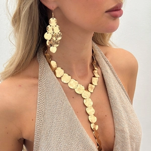 Close-up of golden hammered metal disc earrings and Y-shape tassel necklace set