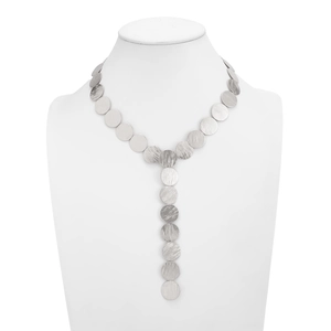 Macro detail of silver geometric discs with brushed texture on a Y-shaped necklace