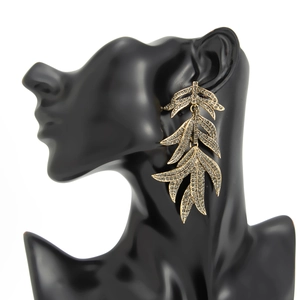 Vue détaillée des boucles d'oreilles feuilles dorées avec strass sur un mannequin