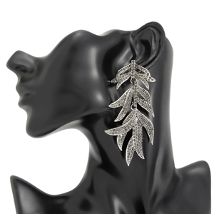 Vue détaillée de grandes boucles d'oreilles feuilles argentées avec strass noirs sur mannequin