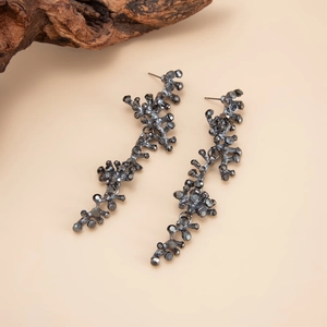 Détail de boucles d'oreilles en forme de corail couleur fusil et cristaux gris foncé