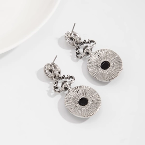 Dettaglio dei orecchini vintage in argento con gemme nere e trame radiali fini