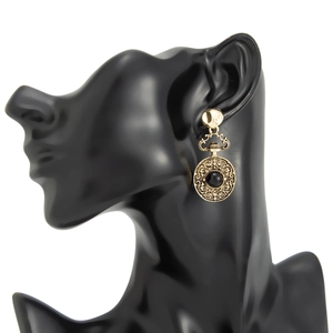 Détail de la boucle d'oreille ronde vintage avec motifs floraux et pierre noire