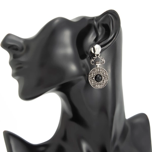 Détail des boucles d'oreilles rétro en argent avec motifs filigranes et pierre noire