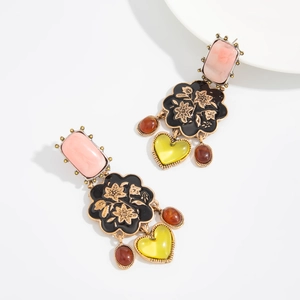 Détail de boucles d'oreilles vintage avec pendentifs coeur et pierres colorées