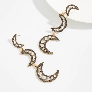 Detailed macro view of cascading crescent moon earrings with rhinestones and gold base