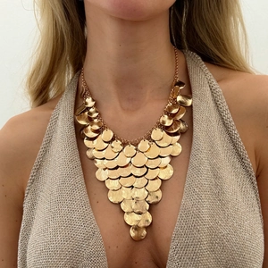 Statement gold layered disc bib necklace with geometric fringe on a model neck