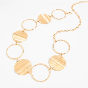 Detail of gold metal body chain with hollow rings and textured circular discs