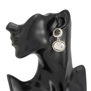 Détails de boucles d'oreilles vintage avec pierres noires et marbrées sur un mannequin