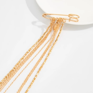 Broche épingle à nourrice dorée avec de longues chaînes à pompons et perles en métal