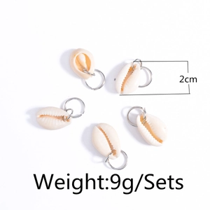 Detail showing natural white shell charms set with silver rings for hair braids