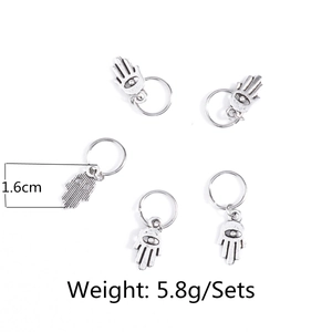 Detail view of five silver alloy Hamsa hand hair rings with vintage textured finish