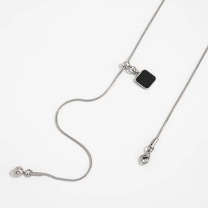 Detail van de zilveren roestvrijstalen slangenketting met vierkante zwarte hanger