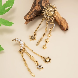 Dettaglio di orecchini bohémien vintage con frange e motivi di sole, luna e stelle