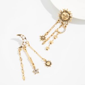 Détail de boucles d'oreilles célestes en or vintage avec pompons asymétriques soleil lune