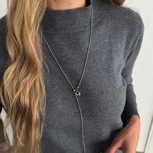 Zilveren geometrische Y-ketting met ronde hanger op een antracietgrijze trui