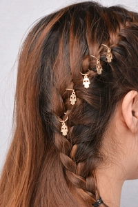 Detailed view of golden Hamsa Hand hair rings on braided hair for hip-hop styling