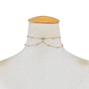 Elegante catena per il corpo dorata con perline e un ciondolo in cristallo di zircone lucente