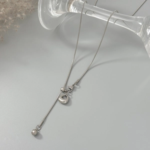 Detail van zilveren slangenketting met ronde bolhanger en een handige karabijnsluiting