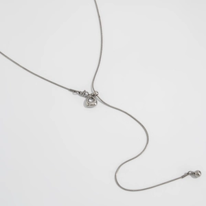 Detail van de zilveren roestvrijstalen slangenketting met ronde hanger en karabijnsluiting
