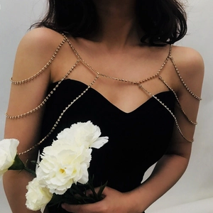 Elegant gold rhinestone body chain with multilayered fringe shawl design worn by model