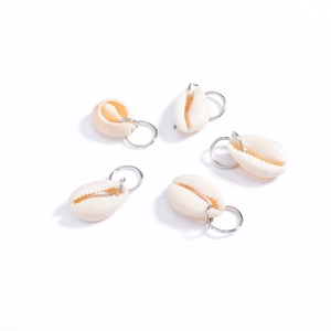 Set of five natural cream-colored shell pendants with silver metal rings on white backdrop