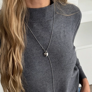 Zilveren roestvrijstalen hart hanger ketting op grijze trui lange verstelbare ketting