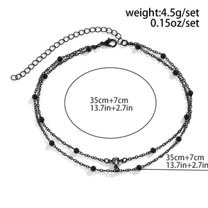 Dettaglio del choker a doppio strato in perline nere con pendente in strass