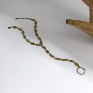 Dettaglio della catena a mano boho in bronzo antico con raffinati motivi floreali in metallo