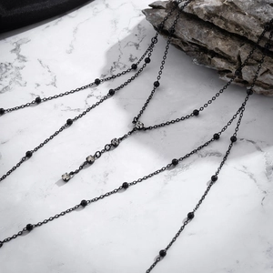 Dettaglio di una catena per il corpo nera multistrato gotica con pendente di cristallo