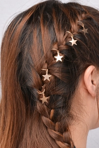 Detail of five golden star charms hair rings woven into dark brown braided dreadlocks