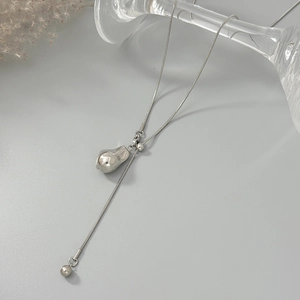 Detailopname van zilveren slangenketting met waterdruppel hanger op een minimalistische achtergrond
