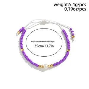 Bracciale regolabile con perline viola, perla sintetica bianca e dettagli oro