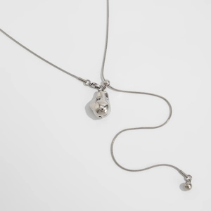 Detail van zilveren slangenketting met organische hanger van vloeibaar metaal