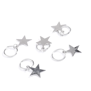 Detail view of five polished silver star charms with small metal rings for hair styling
