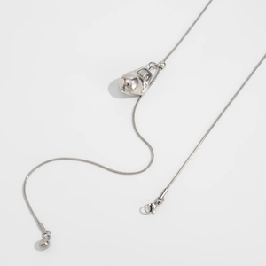 Macro-opname van vloeibaar metalen hart hanger aan verstelbare zilveren slangenketting