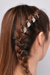 Detailed view of silver leaf pendants woven into a fishtail braid for hair styling