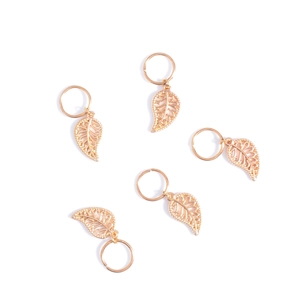 Detailed macro shot of 5 pieces golden leaf charms for braid hair accessories
