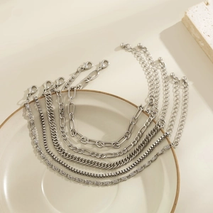 Dettaglio di sei cavigliere color argento con diverse maglie e catenelle regolabili